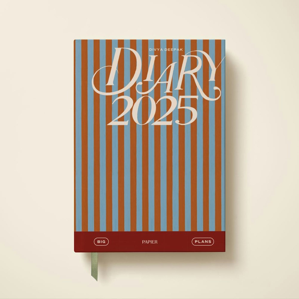 A stripped orange and blue book that reads Diary 2025
